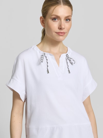 Kobiece modelka nosi T-Shirt mit Tunikakragen und Kordelzug od Marc Cain, biały, mieszanka bawełny z dodatkiem streczu, prosty krój, detale z logo, długość tyłu w rozmiarze 36: 55 cm, zbliżenie na górną część ciała