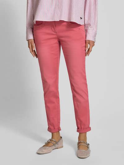 Frauenmodel trägt Relaxed Fit 7/8 Hose aus Baumwoll-Mix von Tom Tailor, Optik: Unifarben, Passform: Relaxed-Fit, 5-Pocket-Design, Materialverarbeitung: Twill, Farbe Rosa, Ganzkörperansicht von vorne.