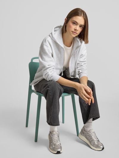 Vrouwenmodel draagt Sweatjacke mit Kapuze van Levi's®, lichtgrijs, katoenmix, losse pasvorm, met capuchon en rits, vooraanzicht heuphoogte.