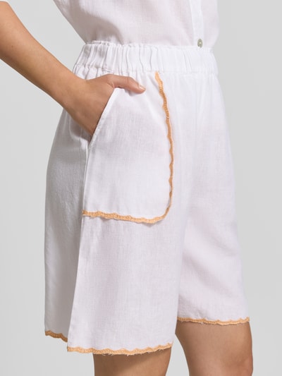 Frauenmodel trägt Bermudas mit Leinen-Anteil und Kontrastkanten von Christian Berg Woman, Viskose-Mix, Loose-Fit, elastischer Bund, Nahaufnahme Oberkörper.