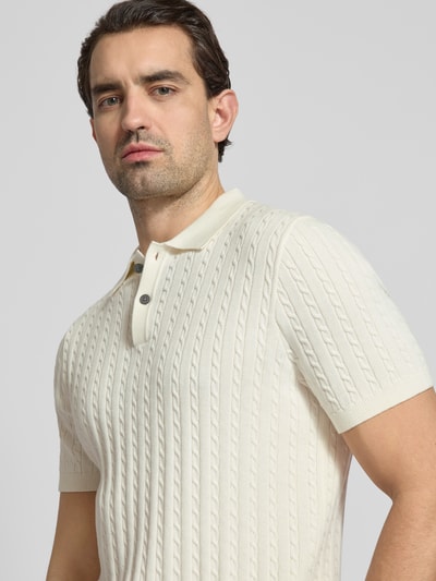 Männermodel trägt Slim Fit Poloshirt in Strick-Optik von Christian Berg Men, cremefarben, Baumwolle, Polokragen, Nahaufnahme Oberkörper.