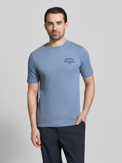 Männermodel trägt T-Shirt mit Rundhalsausschnitt von Scotch & Soda in Blau, Reine Baumwolle, Regular-Fit, Label-Print, Ganzkörperansicht von vorne. Rückenlänge bei Größe M: 68 cm.