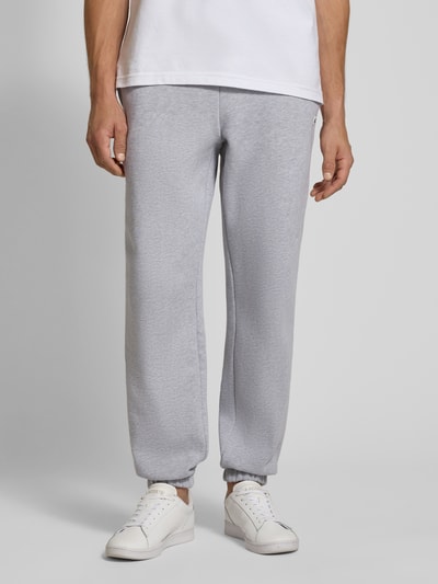 Männermodel trägt Regular Fit Sweathose aus Baumwoll-Mix von Lacoste in Hellgrau, glatte Textur, Ganzkörperansicht von vorne, Herren Sweathose.
