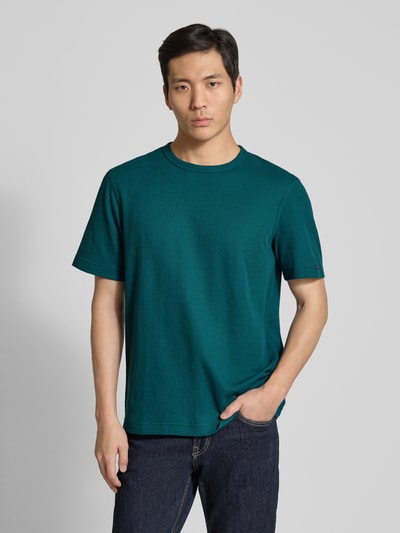 Männermodel trägt Regular Fit T-Shirt aus Baumwoll-Mix von Tom Tailor, Optik: Unifarben, Label-Patch, Rundhals, Kurzarm, Piqué, Ganzkörperansicht von vorne.