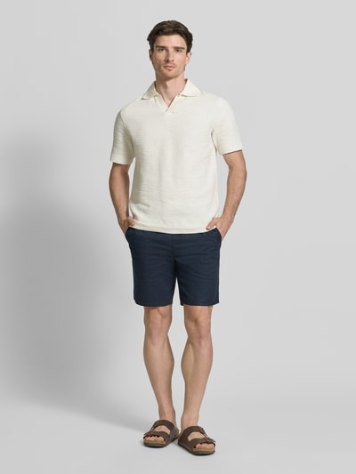 Męski model nosi Regular Fit Poloshirt mit Polokragen Modell 'SAMAC' od Samsøe Samsøe, prosta forma, krótki rękaw, widok z przodu całej sylwetki.