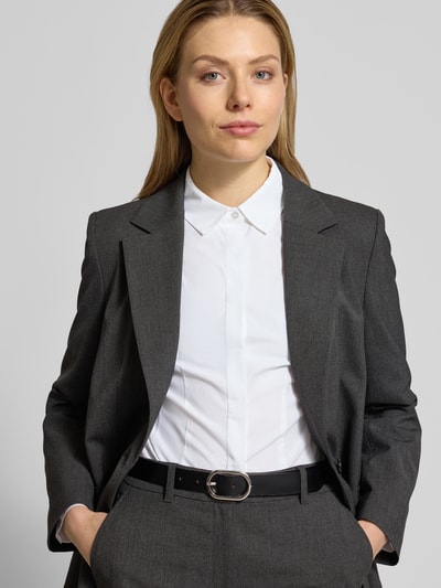 Modelka kobieca nosi Hemdbluse mit Knopfleiste Modell 'NETTI' od Soyaconcept, biały kolor, materiał z domieszką bawełny, krój slim fit, klasyczny kołnierzyk koszulowy, długość tyłu 64 cm, długość rękawa 60 cm, widok na górną część ciała z przodu.