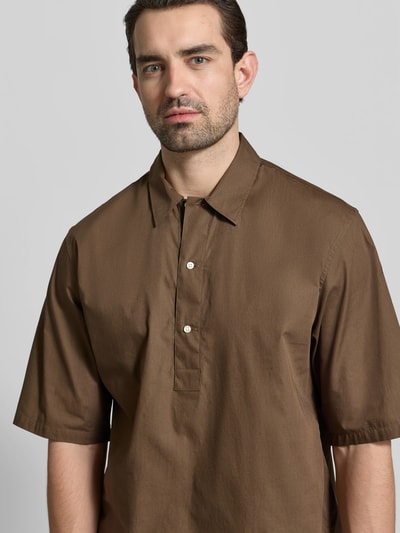 Männermodel trägt Relaxed Fit Freizeithemd mit Kentkragen von Officine Générale aus reiner Baumwolle in Braun, Nahaufnahme Oberkörper. Rückenlänge 74 cm, Schulterbreite 60 cm, Ärmellänge 33 cm, Halbarm, Knopfleiste.
