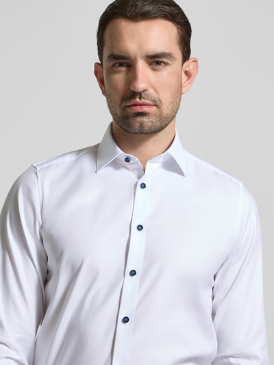 Männermodel trägt Slim Fit Business-Hemd mit Kentkragen von OLYMP Level Five, Unifarbenes-Design, Baumwoll-Mix mit Stretch-Anteil, Nahaufnahme Oberkörper.