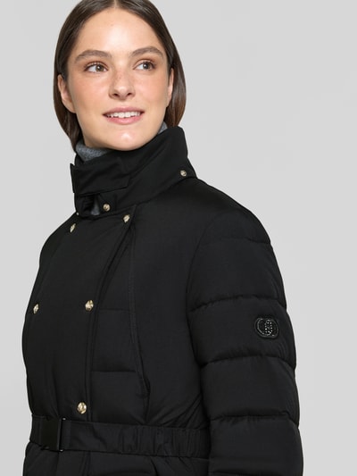 Frauenmodel trägt Jacke mit Kunstfellbesatz Modell 'IMBOTTITO' von Liu Jo, Schwarz mit Ziersteinbesatz und Tailliengurt, Nahaufnahme Oberkörper.