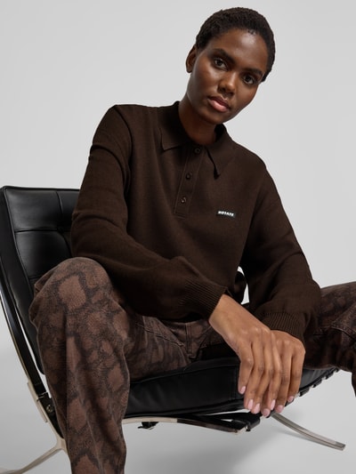 Frauenmodel trägt Oversized Sweatshirt mit Polokragen von ROTATE aus Modal-Woll-Mix, Label-Detail, gerippte Abschlüsse, Nahaufnahme Oberkörper.
