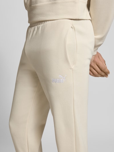 Männermodel trägt Sweatpants mit Label-Stitching von PUMA PERFORMANCE aus Baumwoll-Mix, Regular-Fit, Elastischer Bund, Nahaufnahme Oberschenkel.