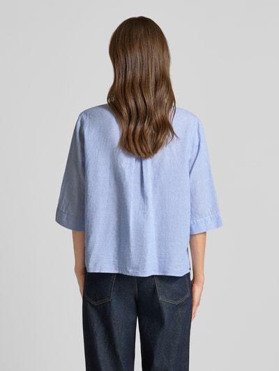 Frauenmodel trägt hellblaue Bluse aus Leinen-Mix mit Brusttaschen Modell 'BEA' von 0039 Italy, strukturierter Stoff, Ganzkörperansicht Rückansicht. Damen Bluse aus Leinen-Baumwoll-Anteil mit Loose-Fit, Hemdblusenkragen, Knopfleiste, 3/4-Arm, Rückenlänge bei Größe S 57 cm, Ärmellänge 37 cm.