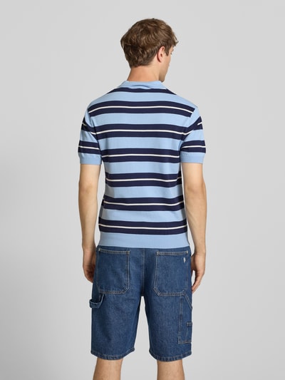 Männermodel trägt Slim Fit Poloshirt aus Viskose-Mix von REVIEW, gestreiftes Design in Blau, Logo-Patch, Polokragen, Rückenlänge 64 cm, Ganzkörperansicht Rückansicht.