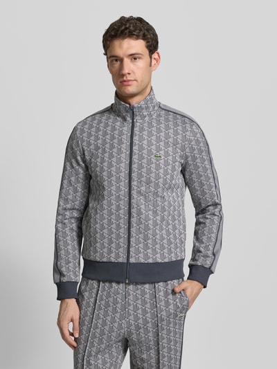 Männermodel trägt Regular Fit Sweatjacke mit Baumwoll-Anteil von Lacoste, Optik:Unifarben, Allover-Muster, Logo-Patch, Kontraststreifen, Stehkragen, Langarm, Reißverschluss, Sweat, Ganzkörperansicht von vorne.