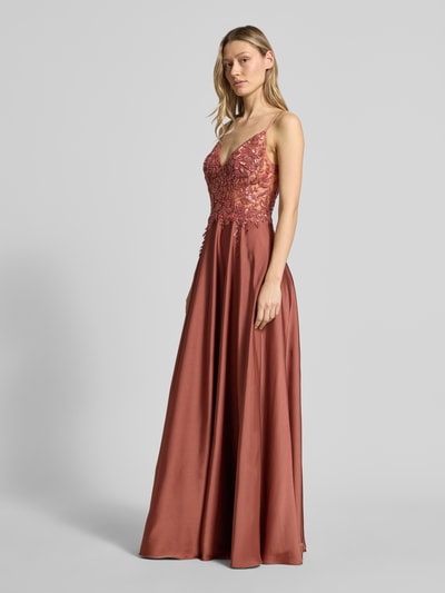Frauenmodel trägt Abendkleid mit floralem Pailettenbesatz von Laona in rostigem Rot, semitransparent, tailliert, Spaghettiträger, florales Stitching, Ganzkörperansicht von vorne.