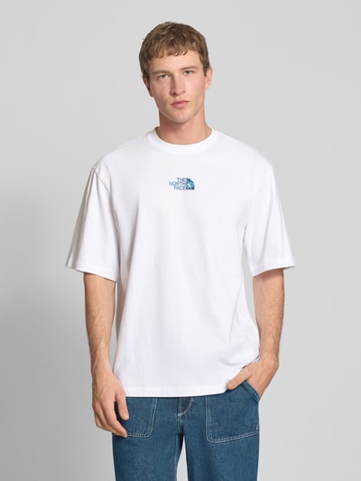 Męski model nosi Oversized T-Shirt mit Logo und Rundhalsausschnitt od The North Face, czysta bawełna, oversize, logo, biały, przód, długość pleców 73 cm w rozmiarze M, Ganzkörperansicht von vorne.
