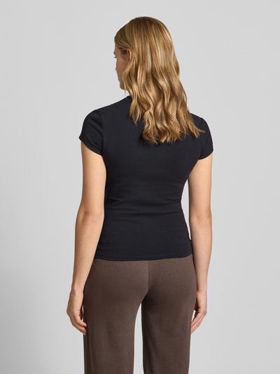 Frauenmodel trägt T-Shirt mit Rundhalsausschnitt von REVIEW aus Baumwoll-Elasthan-Mix, Slim-Fit, Rückenlänge 51 cm, Ganzkörperansicht Rückansicht.