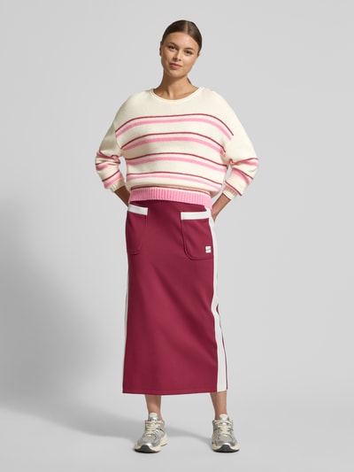 Modelka nosi Regular Fit Pullover aus Alpaka-Mix mit Kaschmir-Anteil od Marc Cain, kremowe tło, różowe paski, dzianinowa faktura, okrągły dekolt, elastyczne wykończenia, długość tyłu w rozmiarze 36: 56 cm, długość rękawa w rozmiarze 36: 51 cm, widok całościowy z przodu.