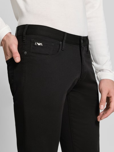 Männermodel trägt schwarze Skinny Fit Jeans aus Baumwoll-Mix von Emporio Armani, 5-Pocket-Design, Nahaufnahme Oberkörper.