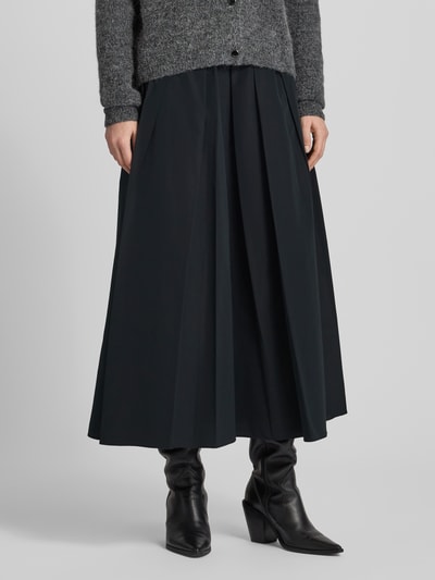Kobiece model prezentuje czarny, jednokolorowy Midi-Rock mit Baumwoll-Anteil Modell 'CURVATO' od Weekend Max Mara, rozkloszowany fason, całkowity widok z przodu.