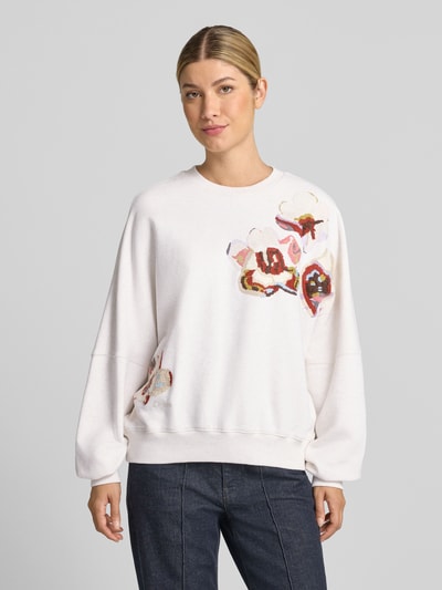 Vrouwenmodel draagt oversized sweatshirt van puur katoen Model 'ASTERA' van DRYKORN met ribboorden en verlaagde schouders, voorkant bovenlichaam close-up.