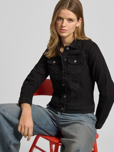 Kobiece model prezentuje kurtkę jeansową Regular Fit Jeansjacke aus Baumwoll-Mix Modell 'WONDER' od Only, efekt: jednolity kolor, krój regular fit, wykładany kołnierz, listwa guzikowa, szwy, pas na plecach, karczek, długi rękaw z mankietami, kieszenie na piersi i wpuszczane, wykończenie materiału: mieszanka bawełny, denim; ujęcie: z przodu, górna część ciała.