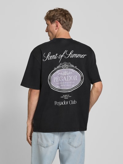 Männermodel trägt oversized T-shirt aus puur katoen mit labelprint, ronde hals, Pegador Oversized T-shirt mit Label-Print Modell 'Ramon', ruglengte maat M 70 cm, ganzlichaamsaanzicht rugaanzicht
