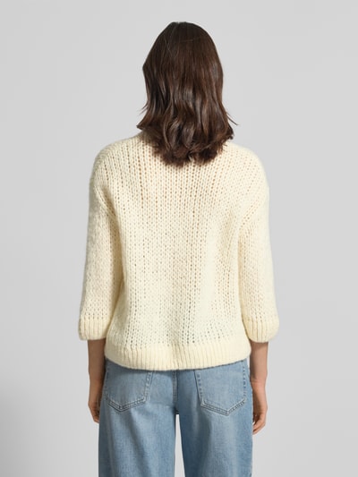 Frauenmodel trägt Regular Fit Pullover mit Woll-Alpaka-Anteil Modell 'Tariah' von Someday in cremefarbener Strick-Optik, elastische Abschlüsse, Rückenlänge 56 cm, Ärmellänge 34 cm, Material-Mix, Ganzkörperansicht Rückansicht.