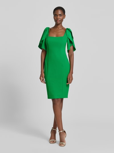 Frauenmodel trägt Cocktailkleid mit Karree-Ausschnitt von Adrianna Papell aus grünem Material-Mix mit Stretch-Anteil, Figurbetontes Minikleid, Ganzkörperansicht von vorne. Rückenlänge 86 cm, Brustweite 39 cm, Ärmellänge 26 cm bei Größe 36.