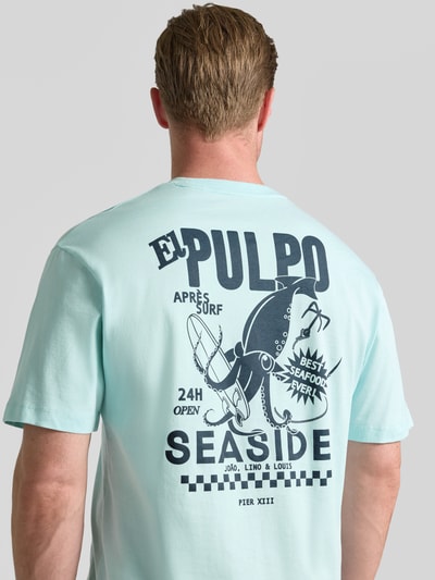 Mannelijk model draagt Regular Fit T-shirt uit puur katoen van s.Oliver RED LABEL, lichtblauw met zwarte print, achteraanzicht, Ganzkörperansicht Rückansicht.