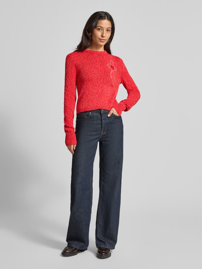 Frauenmodel trägt Slim Fit Strickpullover aus reiner Baumwolle Modell 'IGELO' von MAX&Co., Optik: Unifarben, Melange, Länge: Cropped, Label-Stitching-Applikation, Schleife, Rundhals, Langarm, Ärmelabschluss und Rumpfabschluss gerippt, Materialverarbeitung: Strick, dunkle Jeans, Ganzkörperansicht von vorne.