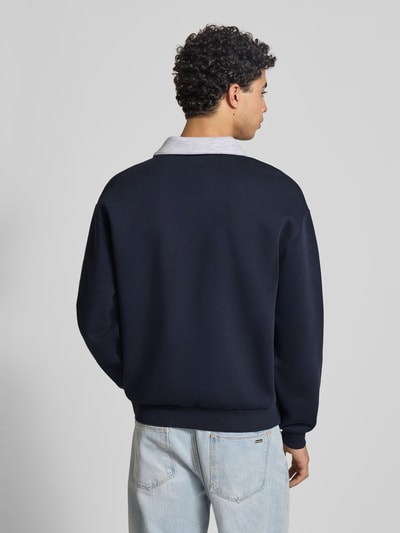 Männermodel trägt Sweatshirt mit Kontrastkragen und Brusttasche mit Logo-Bestickung von REVIEW, Materiaalmix met katoen, regular fit, contrastkraag, borstzak met geborduurd logo, ruglengte maat M 71 cm, mouwlengte maat M 63 cm, donkerblauw, Ganzkörperansicht Rückansicht.