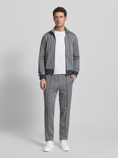 Männermodel trägt Regular Fit Sweathose mit Baumwoll-Anteil von Lacoste, Optik:Allover-Muster, abstrakt, Sweat, Ganzkörperansicht von vorne.