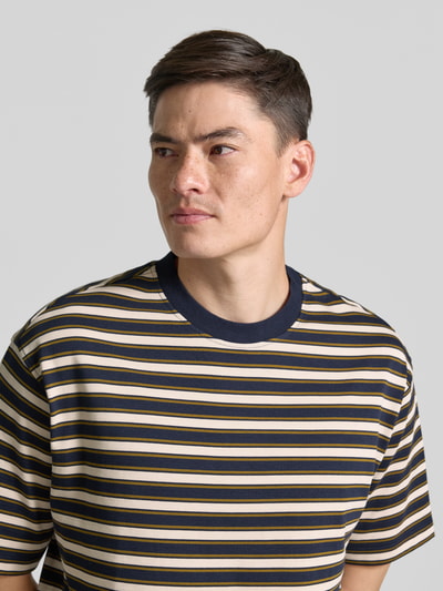 Męski model nosi Relaxed Fit T-Shirt aus reiner Baumwolle Modell 'ASPEN 2' von SELECTED HOMME w poziome paski, zbliżenie na górną część ciała.