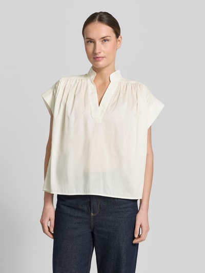 Vrouwenmodel draagt Relaxed Fit blouse met tuniekhals model 'Mirtilla' van Stefanel in puur katoen, ruglengte maat XS/S 58 cm, mouwlengte 10 cm, dames blouse met korte mouwen, crèmekleurig, rechte vormen, soepele lichte textuur. Ganzkörperansicht van voren.