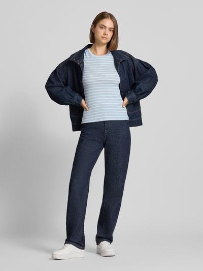 Vrouwenmodel draagt Slim Fit T-Shirt uit katoenmix Model 'RUKA' van Pieces met lichtblauw-wit streepmotief, fijnribstructuur, ronde hals, korte mouwen, effen kleuren, all-over motief, Ganzkörperansicht van voren.