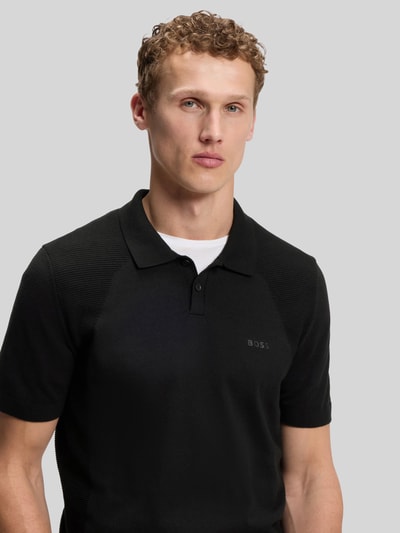 Männermodel trägt Poloshirt mit Logo Detail von BOSS Green, Optik: Unifarben, Passform: Regular-Fit, Logo-Print, Bodymapping-Struktur, Nahaufnahme Oberkörper.