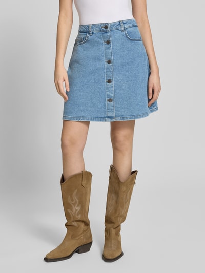 Modelka nosi Jeansrock mit Knopfleiste Modell 'RONNIE' von Noisy May, bawełniany miks z wiskozą, krój A-linia, minispódnica, niebieski denim, guziki, szerokość w rozmiarze S 40 cm, długość całkowita 47 cm, pełny widok od przodu