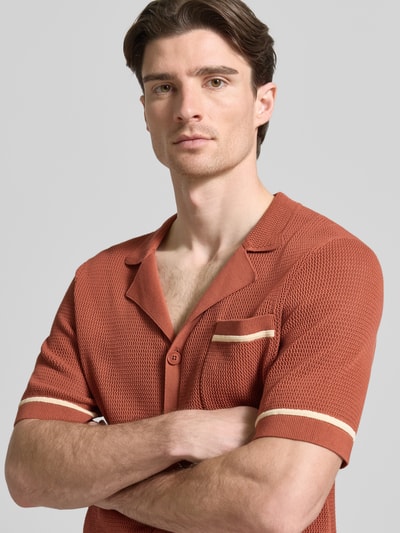 Männermodel trägt Slim Fit Freizeithemd in Strick-Optik Modell 'FLAVIRO' von Drykorn in rostrot mit cremefarbenen Details, Nahaufnahme Oberkörper, reine Baumwolle, Reverskragen, 1/2-Arm, Knopfleiste, Brusttasche.