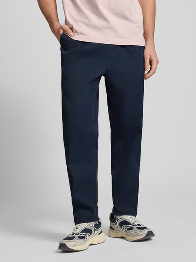 Männermodel trägt Straight Fit Chino mit Bundfalten von G-Star Raw in Dunkelblau, elastischer Material-Mix, Eingriff- und Gesäßtaschen, Ganzkörperansicht von vorne.