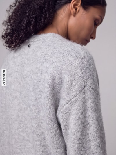 Frauenmodel trägt Relaxe-Fit Strickjacke aus Alpacka-Mix mit Woll-Anteil Modell 'C_Farano' von BOSS Orange in grauer Melange-Optik, Stricktextur, Detailaufnahme, KI-modifiziertes Bild