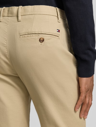 Männermodel trägt Slim Fit Chino aus Baumwoll-Mix von Tommy Hilfiger, Optik: Unifarben, Logo-Stitching, Nahaufnahme Gesäßtasche.