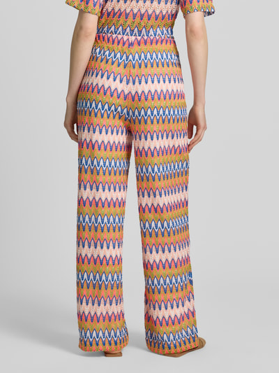 Frauenmodel trägt Hose im Allover-Look mit elastischem Bund von Smith and Soul, Relaxed-Fit, Strukturmuster, bunte Zickzacklinien, Ganzkörperansicht Rückansicht.