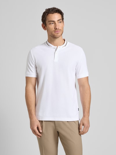 Männermodel trägt Regular Fit Poloshirt aus einer Baumwolle C-PRATT40 von BOSS, Optik: Unifarben, Materialverarbeitung: Piqué, Reine Baumwolle, kurzarm, V-Ausschnitt, kurze Knopfleiste, Label-Stitching-Applikation, Bündchen: Gerippt. Ganzkörperansicht von vorne.