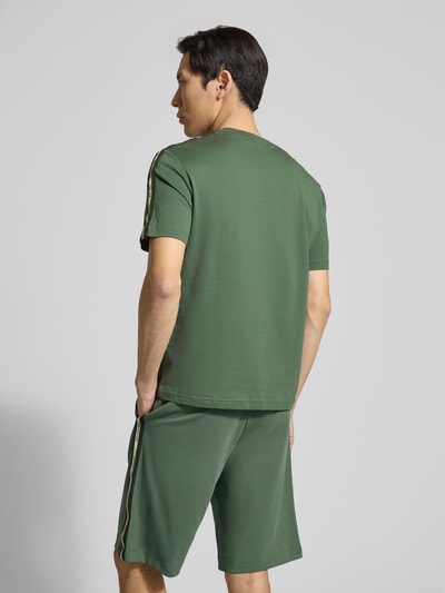 Męski model ma na sobie Regular Fit T-Shirt mit Logo-Patch od EA7 Emporio Armani, czysta bawełna, krój regular fit, długość tyłu w rozmiarze M: 52 cm, widok całej sylwetki z tyłu.