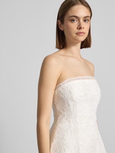 Frauenmodel trägt Cocktailkleid im Off-Shoulder-Look von Bardot, weißes Mesh, A-Linie, florale Textur, Nahaufnahme Oberkörper.