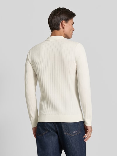 Männermodel trägt Regular Fit Poloshirt aus reiner Baumwolle Modell 'TORINO' von Selected in Creme mit feiner Rippenstruktur, Ganzkörperansicht Rückansicht.