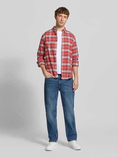 Männermodel trägt Tapered Fit Jeans aus bawełniano-poliestrowy mix Model 'SONNY' von Tommy Jeans, kolor denim, krój regular fit, 5 kieszeni, naszywka z logo, nity, szlufki na pasek, zapięcie na guzik i ukryty zamek, Ganzkörperansicht von vorne.