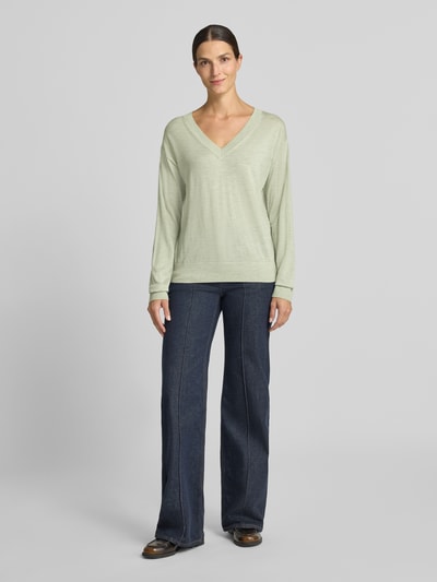 Frauenmodel trägt Regular Fit Pullover aus reiner Schurwolle Modell 'Freeslyn' von BOSS in Hellgrün und dunkler Hose, Ganzkörperansicht von vorne, Damen Pullover von BOSS.