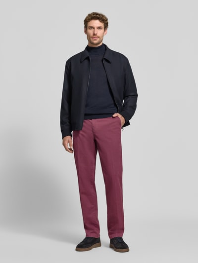 Männermodel trägt Regular Fit Chino aus Baumwoll-Mix Modell 'Evans' von Brax in Bordeaux, unifarben, Twill-Struktur, Ganzkörperansicht von vorne.